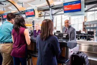 Travelers check in at a Delta counter in Atlanta